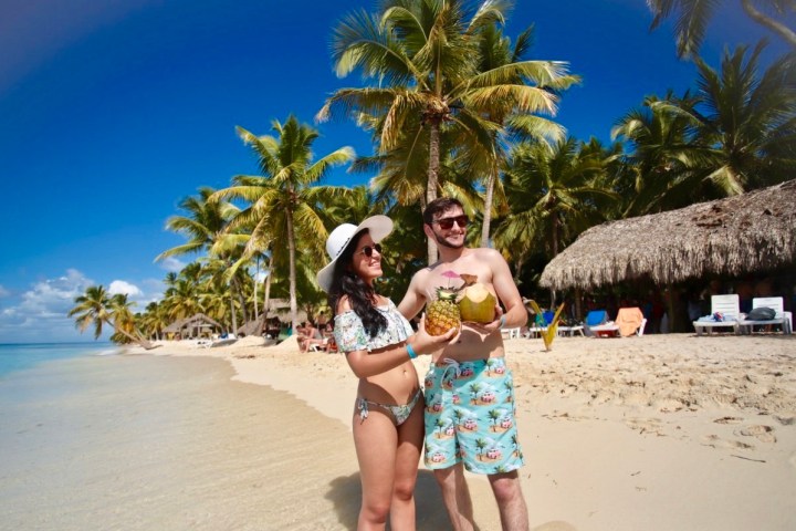 a person standing in front of palm trees on a beach