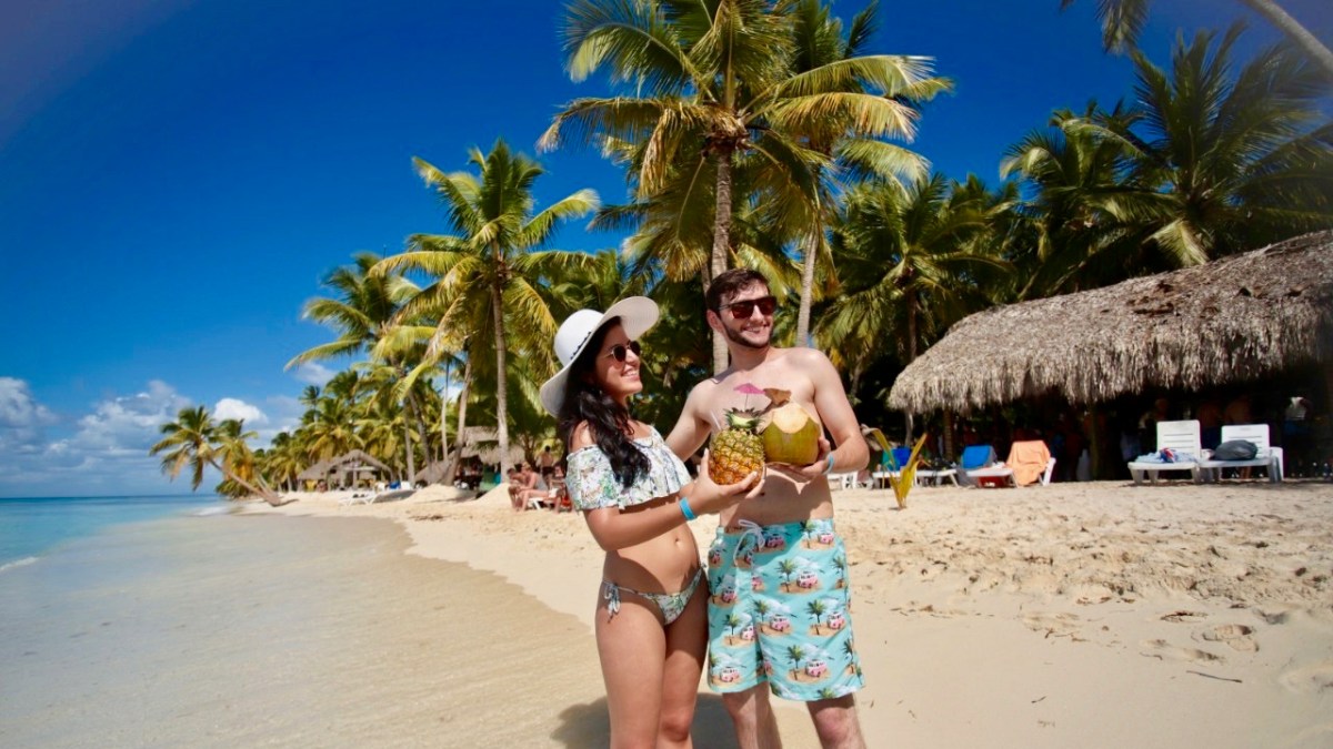 a person standing in front of palm trees on a beach